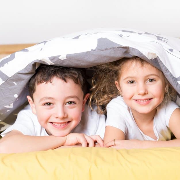 Frère et sœur qui relaxent sur le lit