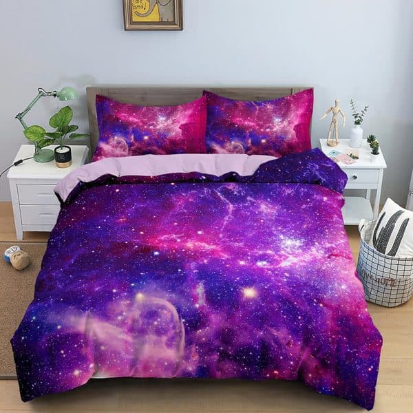 Dans une chambre un lit, avec table de chevet de chaque coté, est couvert d'une parure complete de lit avec des étoiles et des galaxies dans les tons violets et fushia