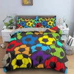 Dans une chambre un lit, avec table de chevet de chaque coté, est couvert d'une parure complete de lit recouverte entièrement de ballons de football de toutes les couleurs