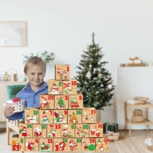 Petit garçon ouvrant une boite du calendrier de l'avent à remplir, dans un salon avec un décor de Noël.