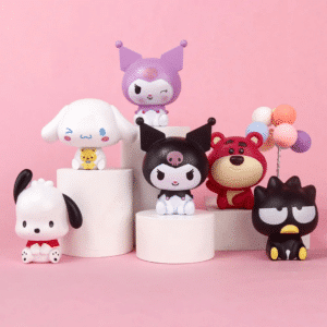 Petits personnages Sanrio à gateau exposés sur de petits gâteaux, sur fond rose.