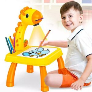 Un garçon de 5 ou 6 ans assis par terre tenant un crayon dans la main et dessinant sur une table ardoise girafe avec projection de dessin. La girafe est jaune et orange
