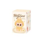 Boite en carton blanche, avec un labubu jaune dessiné dessus sur fond blanc