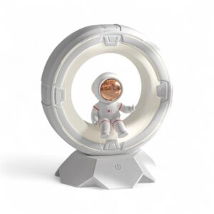 Veilleuse astronaute LED tactile pour garçon représentant un astronaute assis sur un cercle semblable une lune sur fond blanc