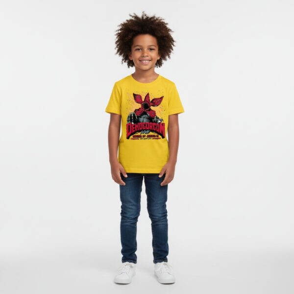 Petit garçon portant un t-shirt Stranger Things jaune, sur fond gris