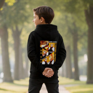 Un jeune garçon de dos porte un sweat Demon Slayer Rengoku le Pilier de la Flamme de couleur noire avec une illustration colorée dans le dos, debout sur un trottoir bordé de grands arbres verdoyants sous une lumière douce.