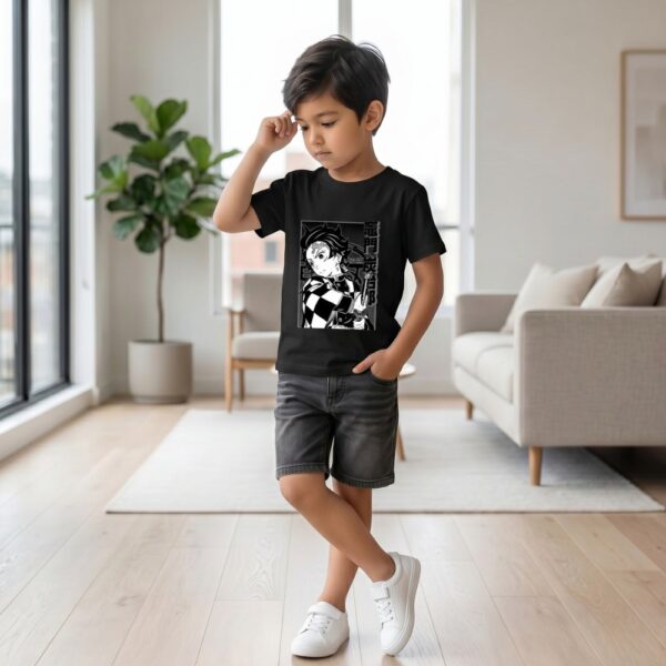 Un jeune garçon portant un t-shirt Demon Slayer Tanjiro imprimé en noir et blanc, dans un salon lumineux avec un canapé et une plante verte en arrière-plan.