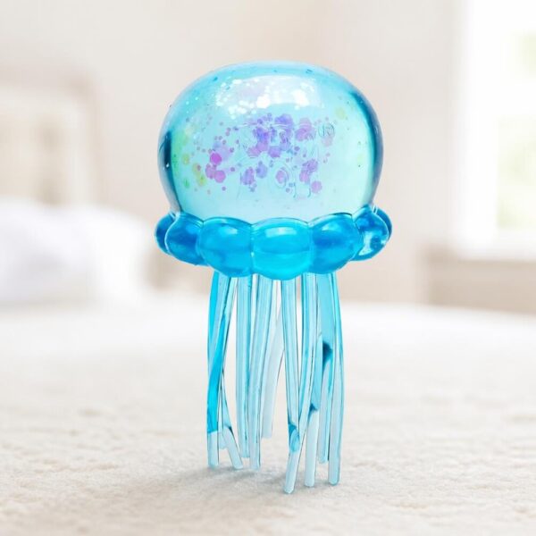 Offrez à votre enfant ce jouet sensoriel anti-stress Needoh méduse squishy, une méduse en gel pailleté aux tentacules souples à presser sans fin. Disponible en bleu, rose ou violet, elle accompagne les instants calmes, les trajets et les pauses concentration à la maison comme à l'école. Version non officielle.
