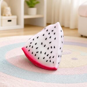 Un Jouet Squishy garçon en quartier de fruit du dragon blanc et rose, posé sur un tapis rond dans une chambre lumineuse.