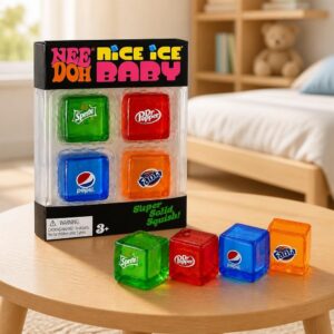Un Jouet Squishy Needoh garçon sensoriel en mini cubes colorés, posé sur une table ronde, avec quatre cubes translucides verts, rouges, bleus et orange dans une chambre lumineuse.